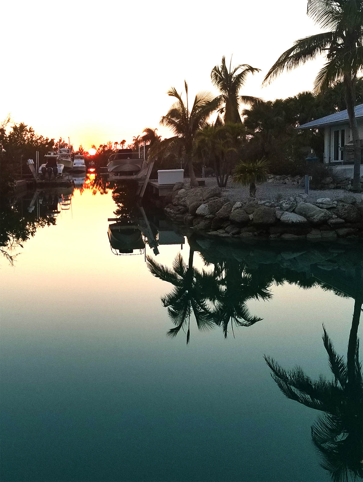 The outdoor dining table looks directly down a crossing canal, perfect for enjoying sunsets nightly